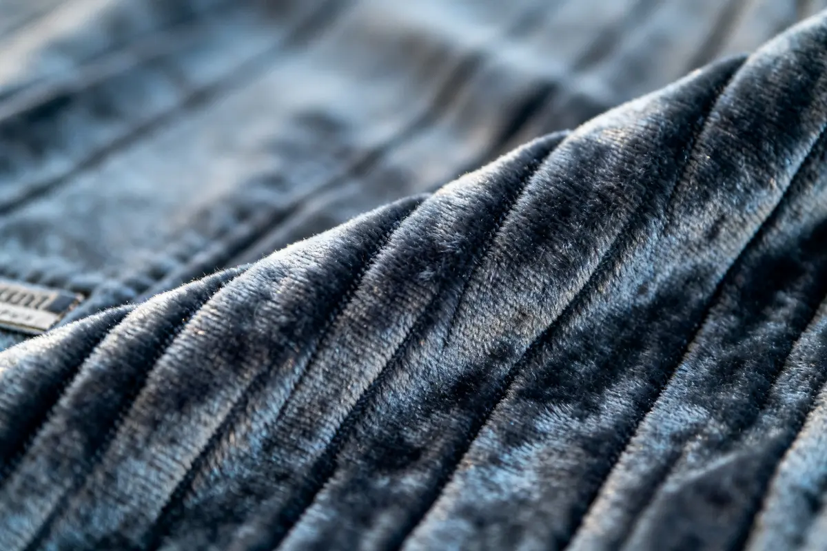 Tissu gris en velours côtelé plié avec texture douce et striée en gros plan