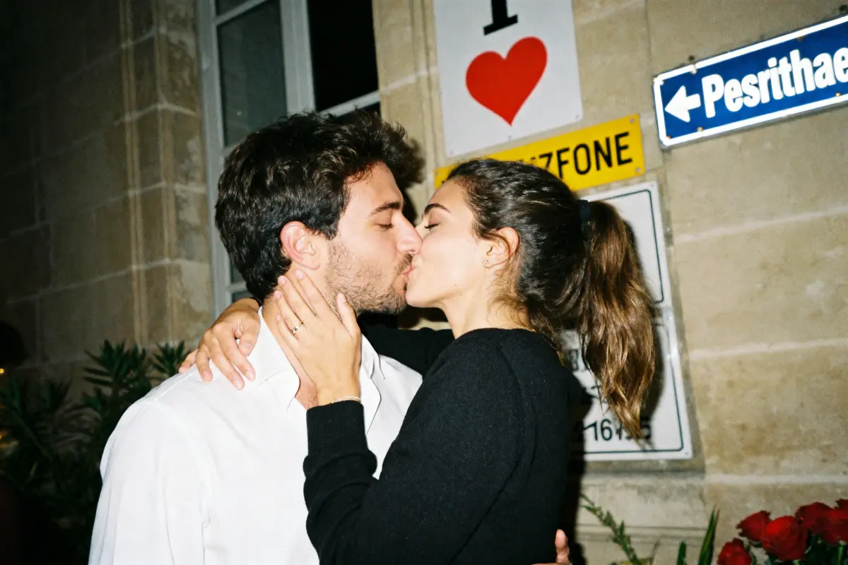 Un couple s'embrasse tendrement lors d'une soirée romantique célébrant un anniversaire avec amour.